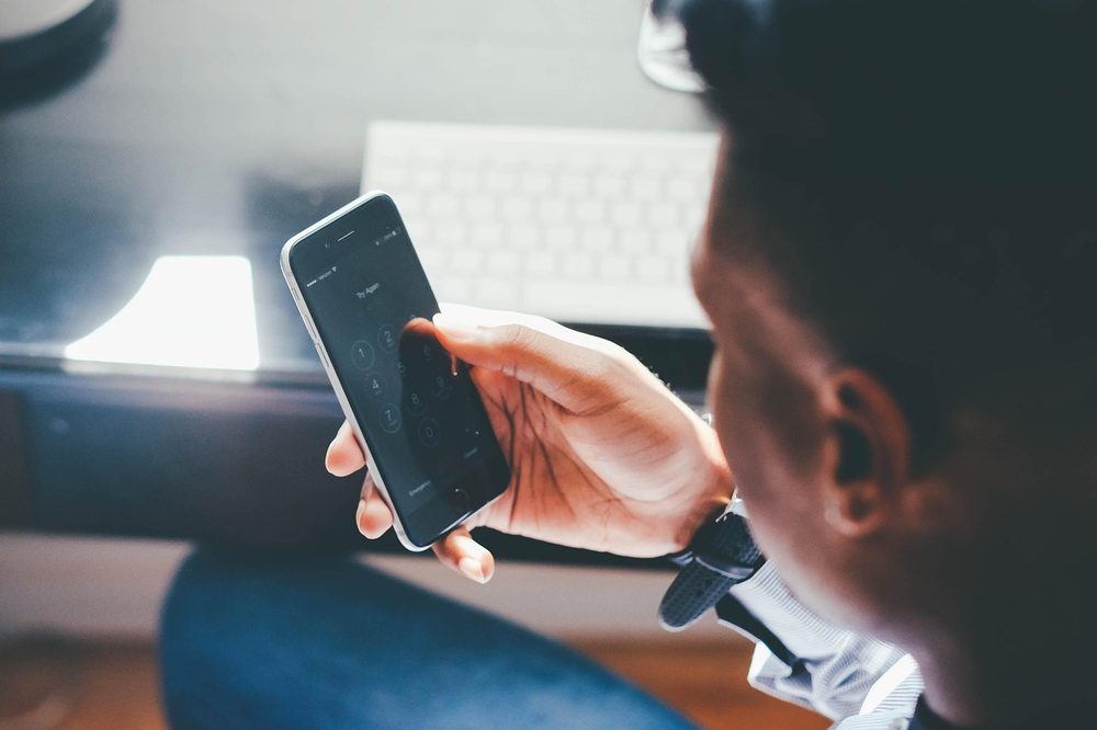 男性がiPhoneの画面を操作する手元｜SNS時代のイナゴ化典型パターンを示すイメージ