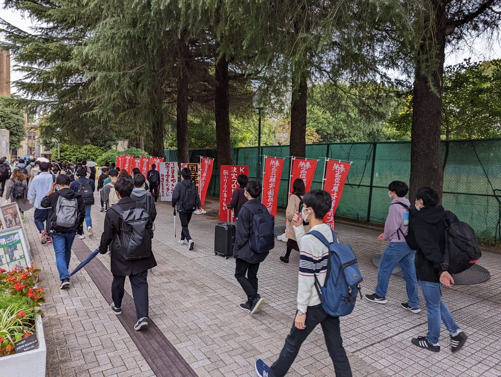 大学のキャンパスを歩く学生たち