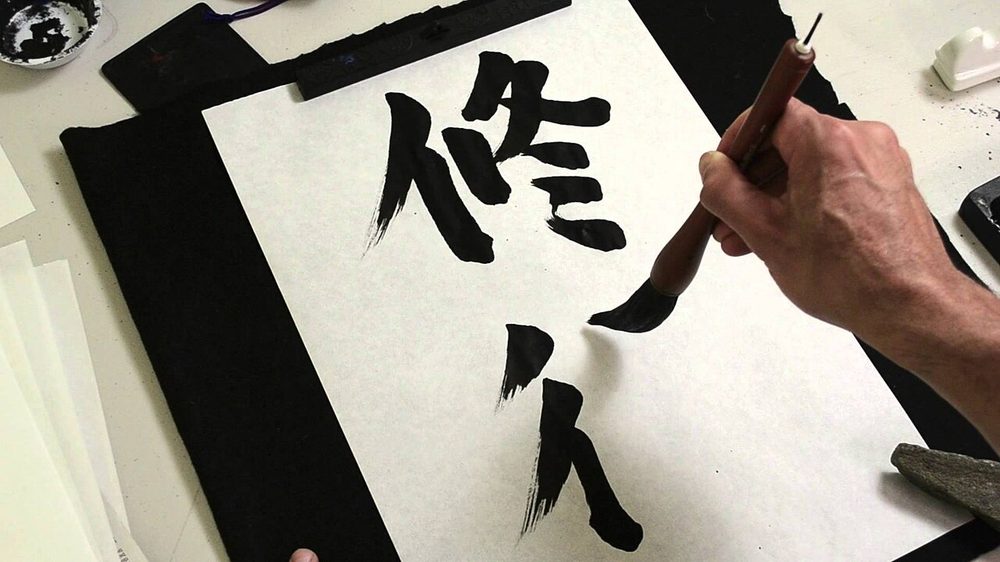 筆で漢字を書く様子。当て字は日本語ならではの漢字表現