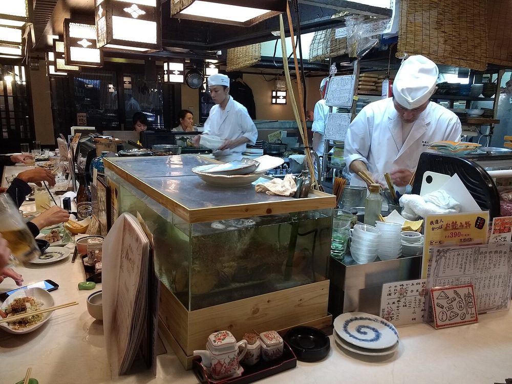 和食店のカウンターで仕込みをする板前