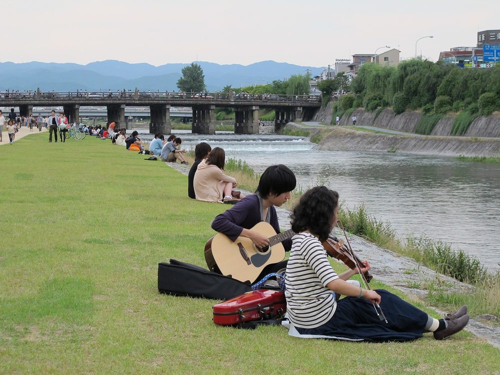 京都・鴨川の河川敷でくつろぐ人々