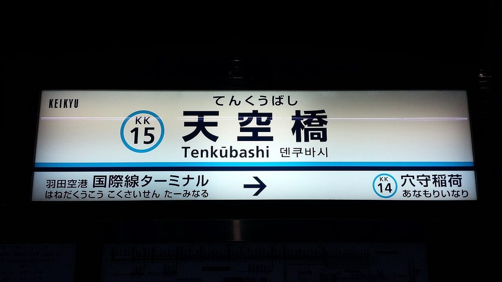 天空橋駅の駅名標に書かれたヘボン式ローマ字Tenkubashi（長音記号つき）