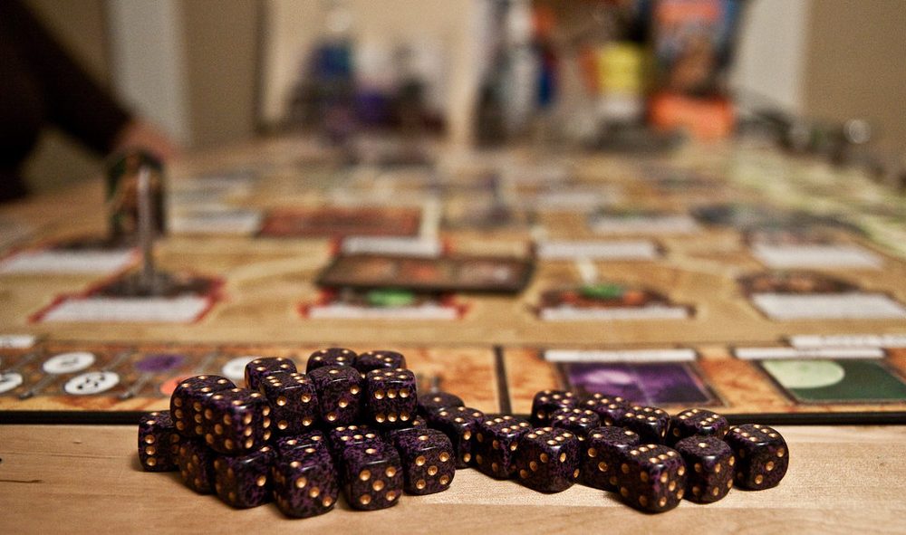 テーブルに広げられたボードゲームとダイス