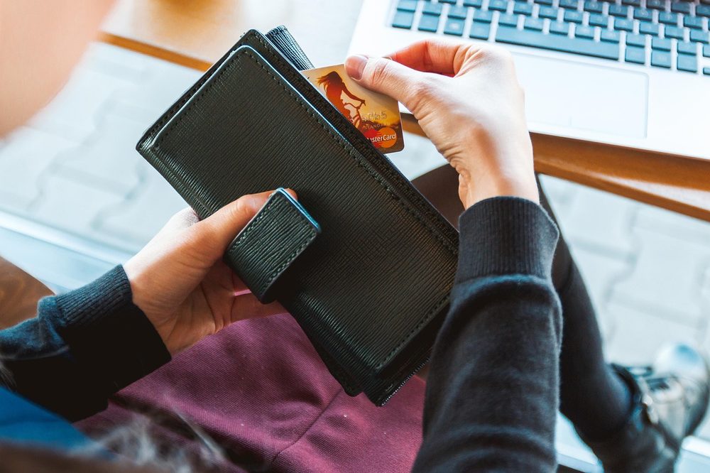 財布とクレジットカードとノートパソコン 教科書をネットで安く買うイメージ